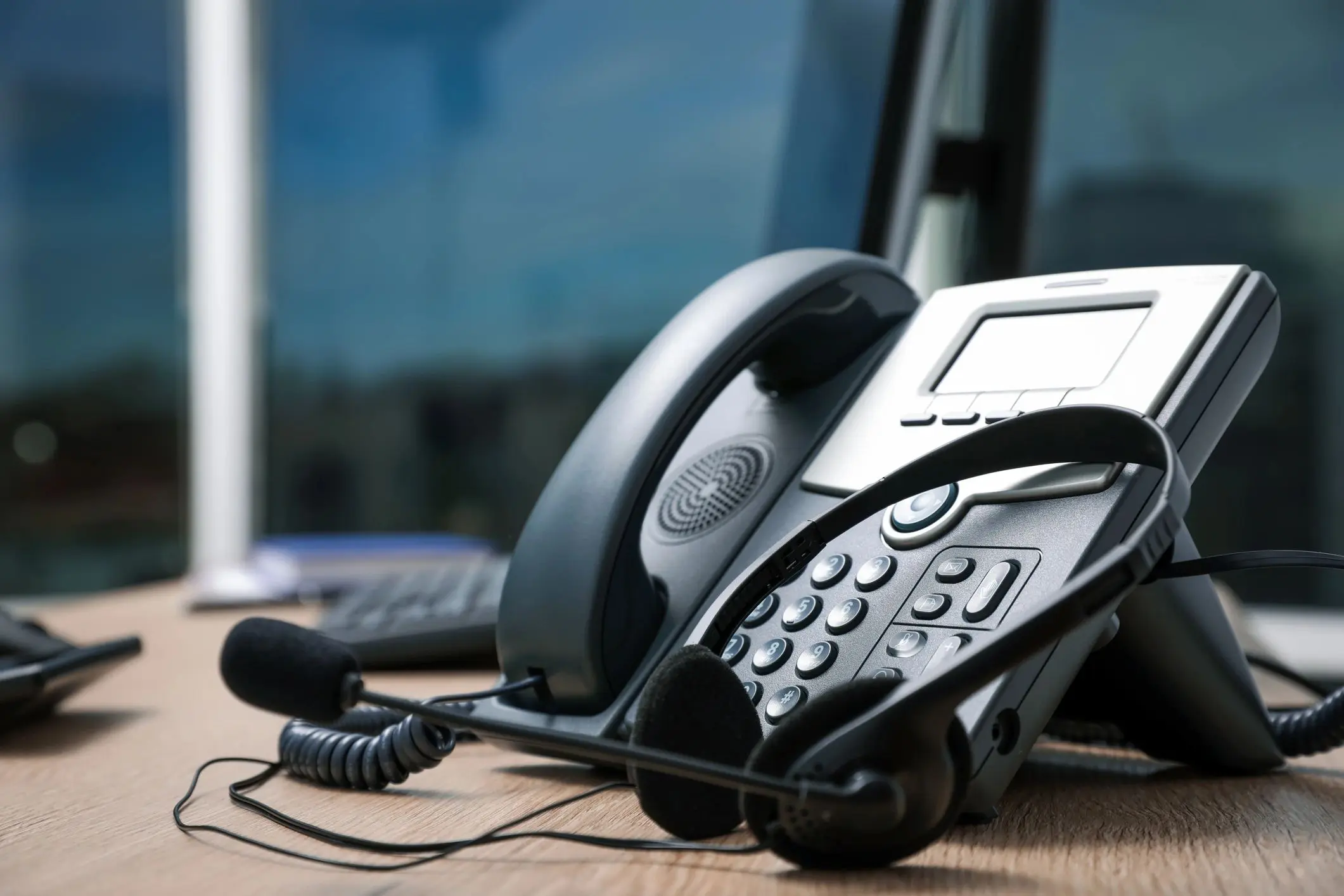Office desk phone with headset and computer.