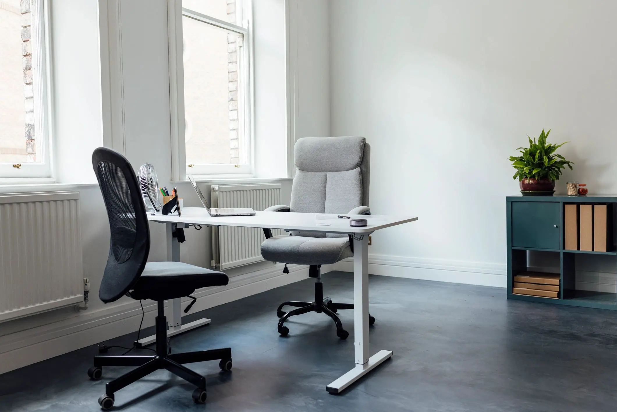 Minimalist office with two chairs and desk.