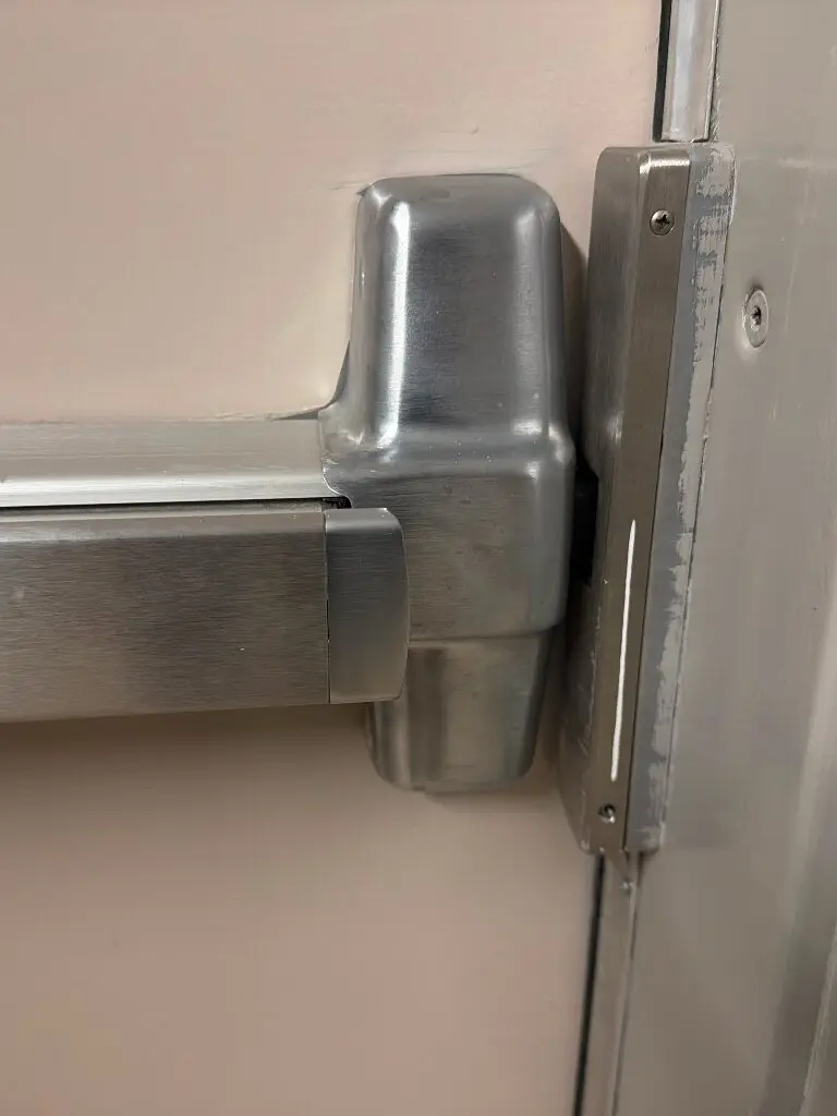 Stainless steel panic bar on beige door