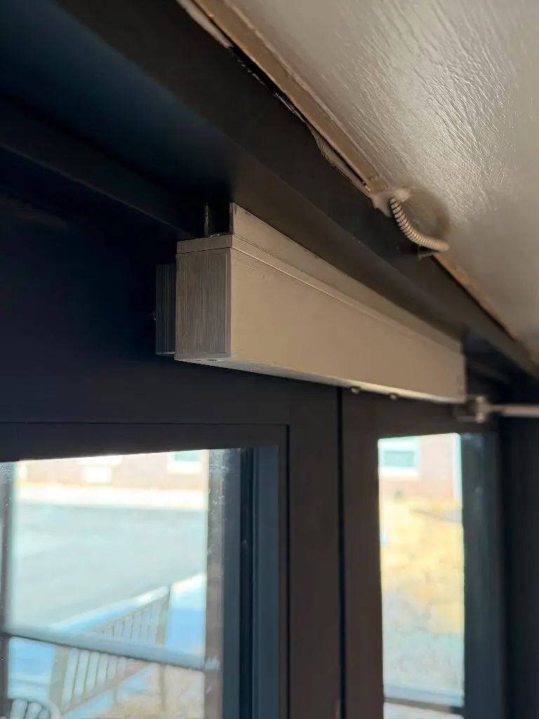 Window blind headrail mounted above glass door
