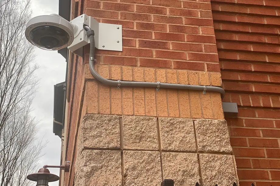 Dome security camera mounted on brick wall