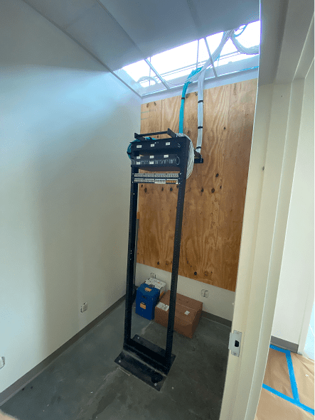 Network equipment rack mounted in utility closet