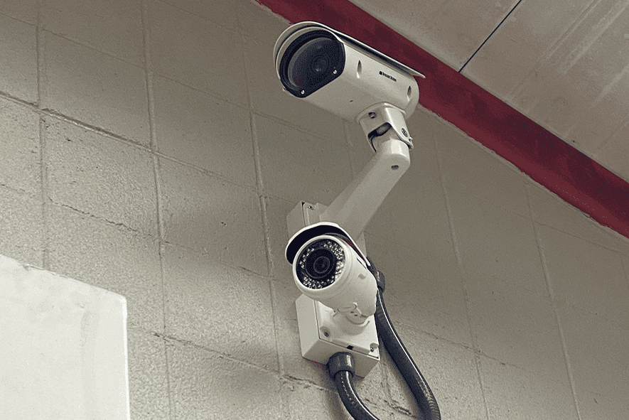 Dual security cameras mounted on indoor wall