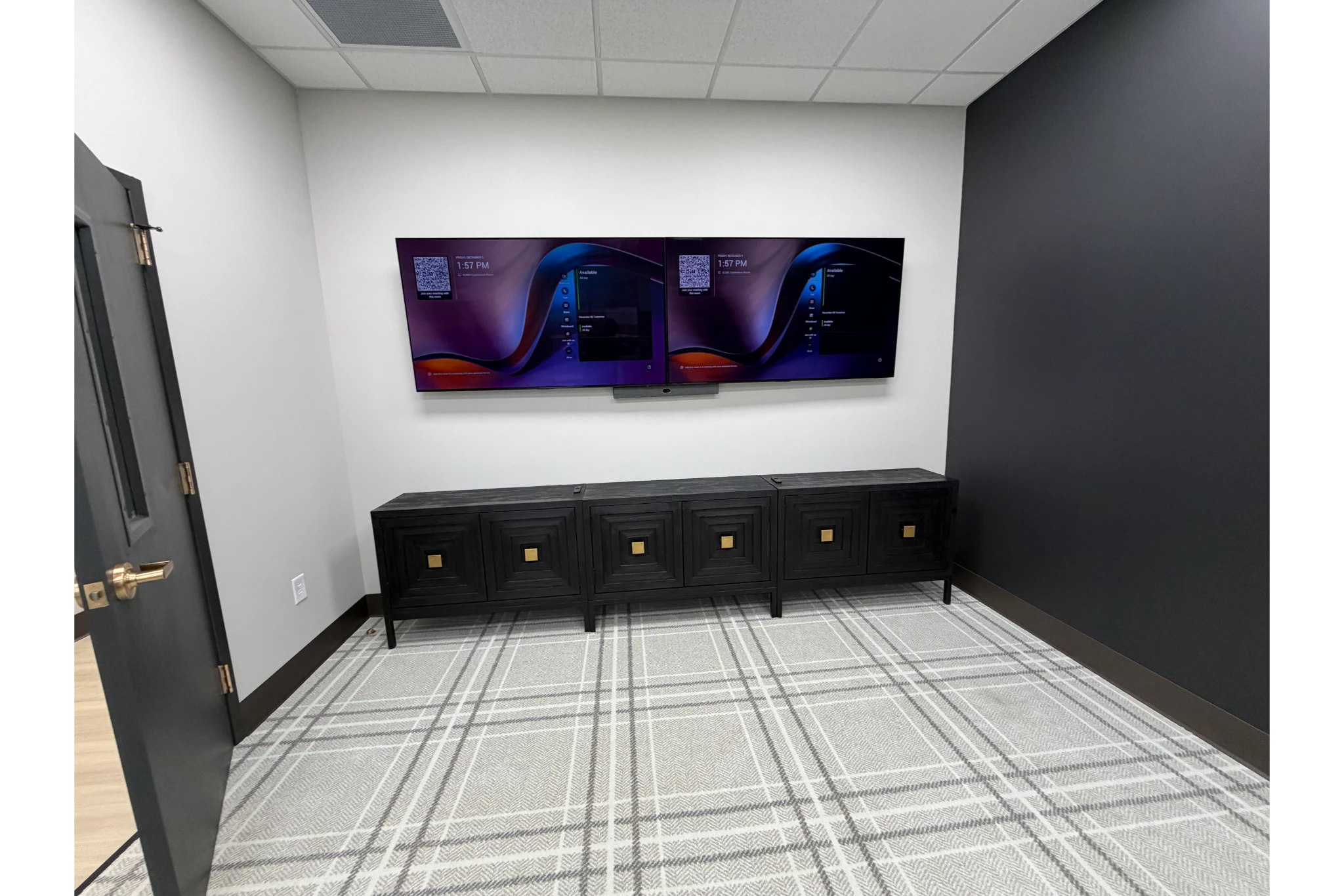 Empty meeting room with dual wall-mounted monitors