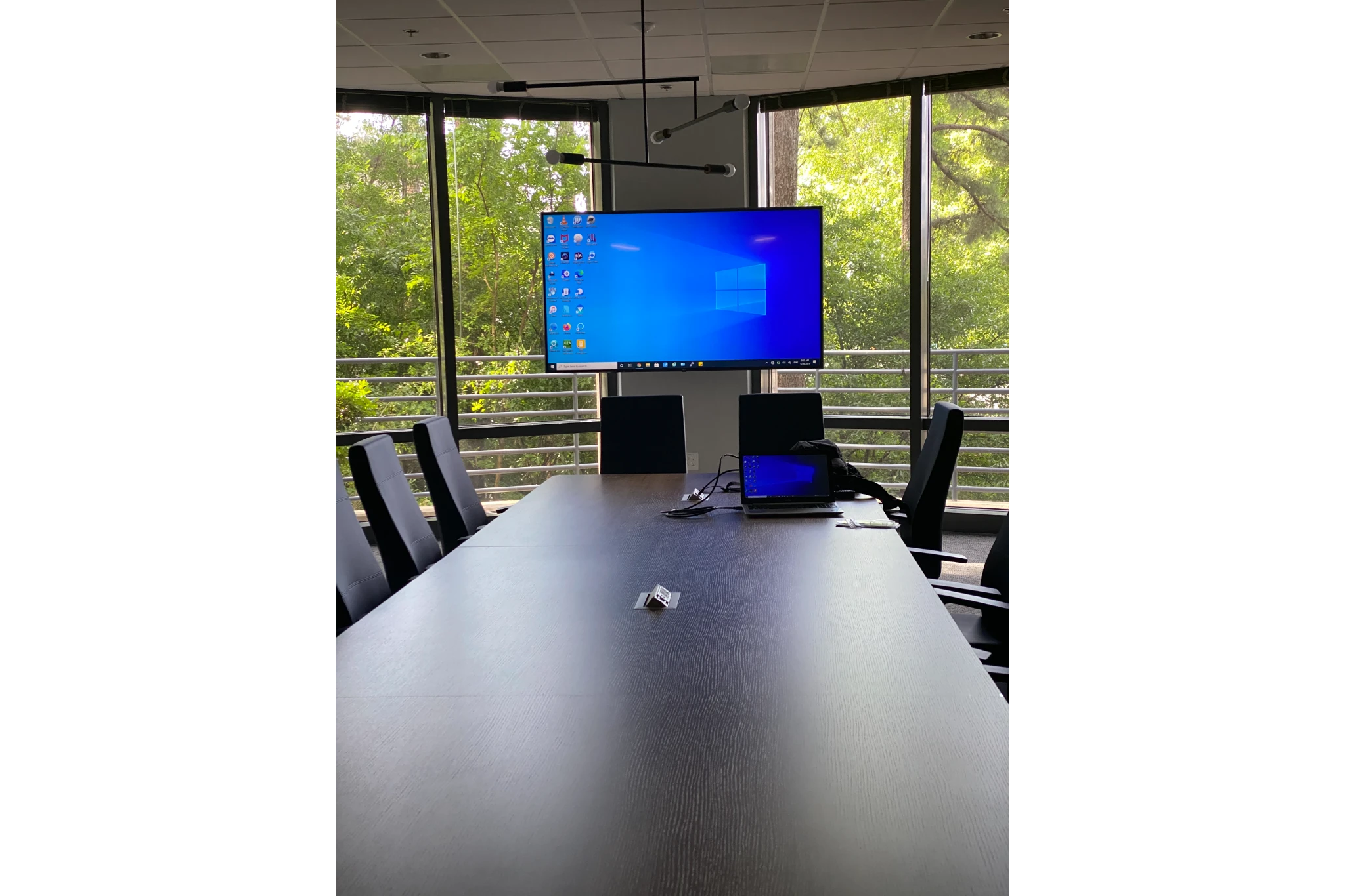 Conference room with monitor, laptop, and windows