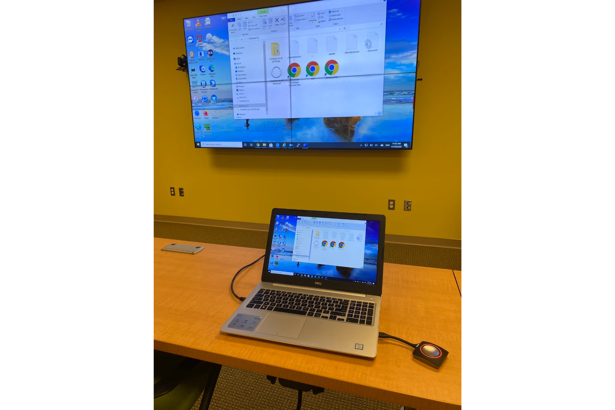 Laptop connected to wall monitor in meeting room