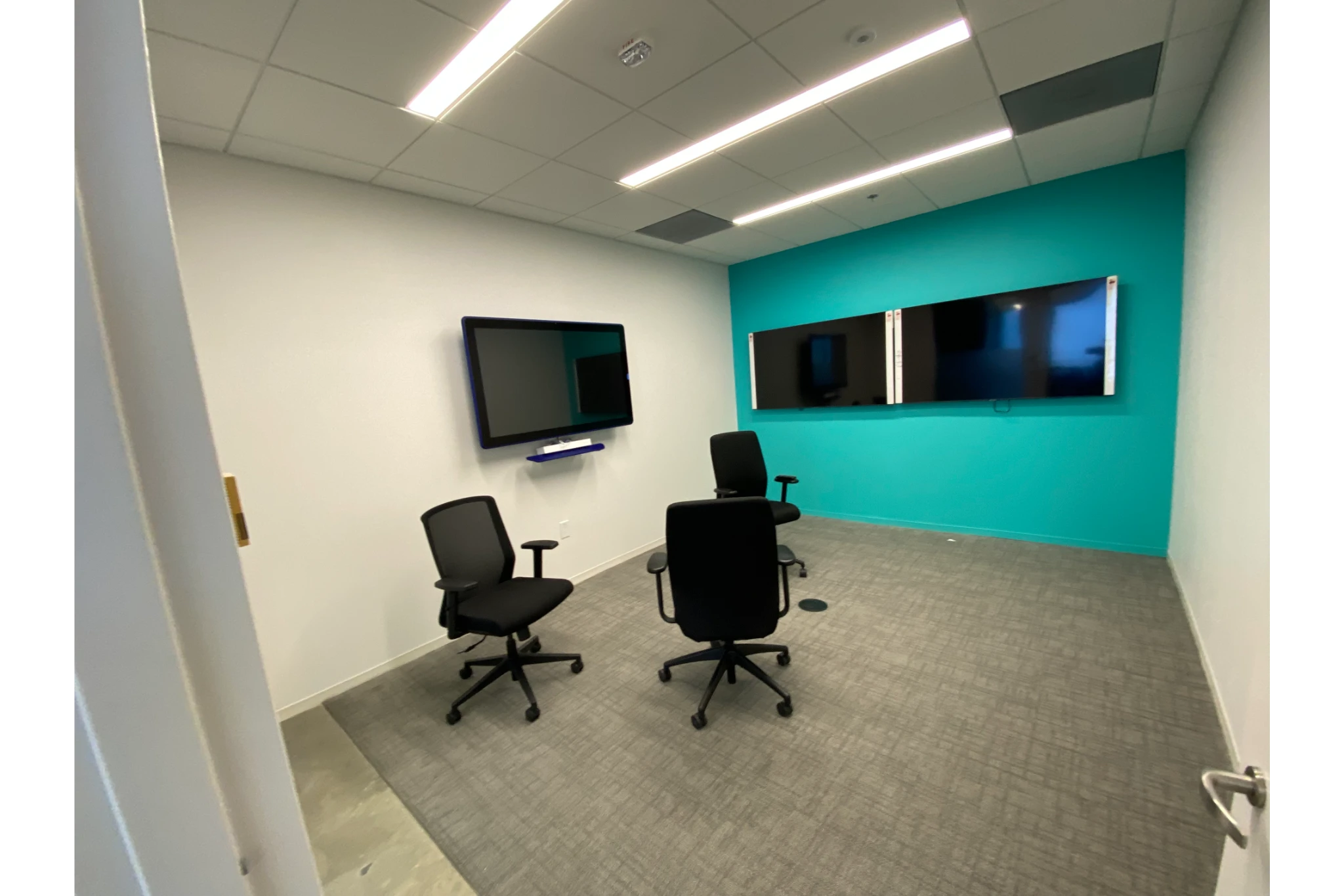 Small conference room with monitors and chairs