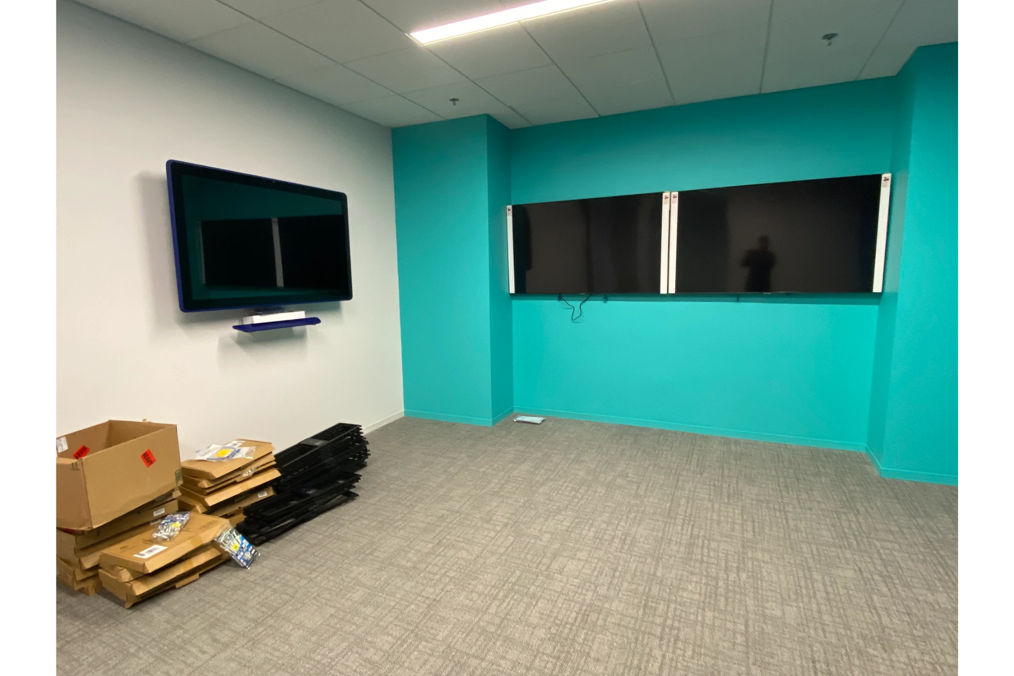 Empty office with wall-mounted monitors and boxes