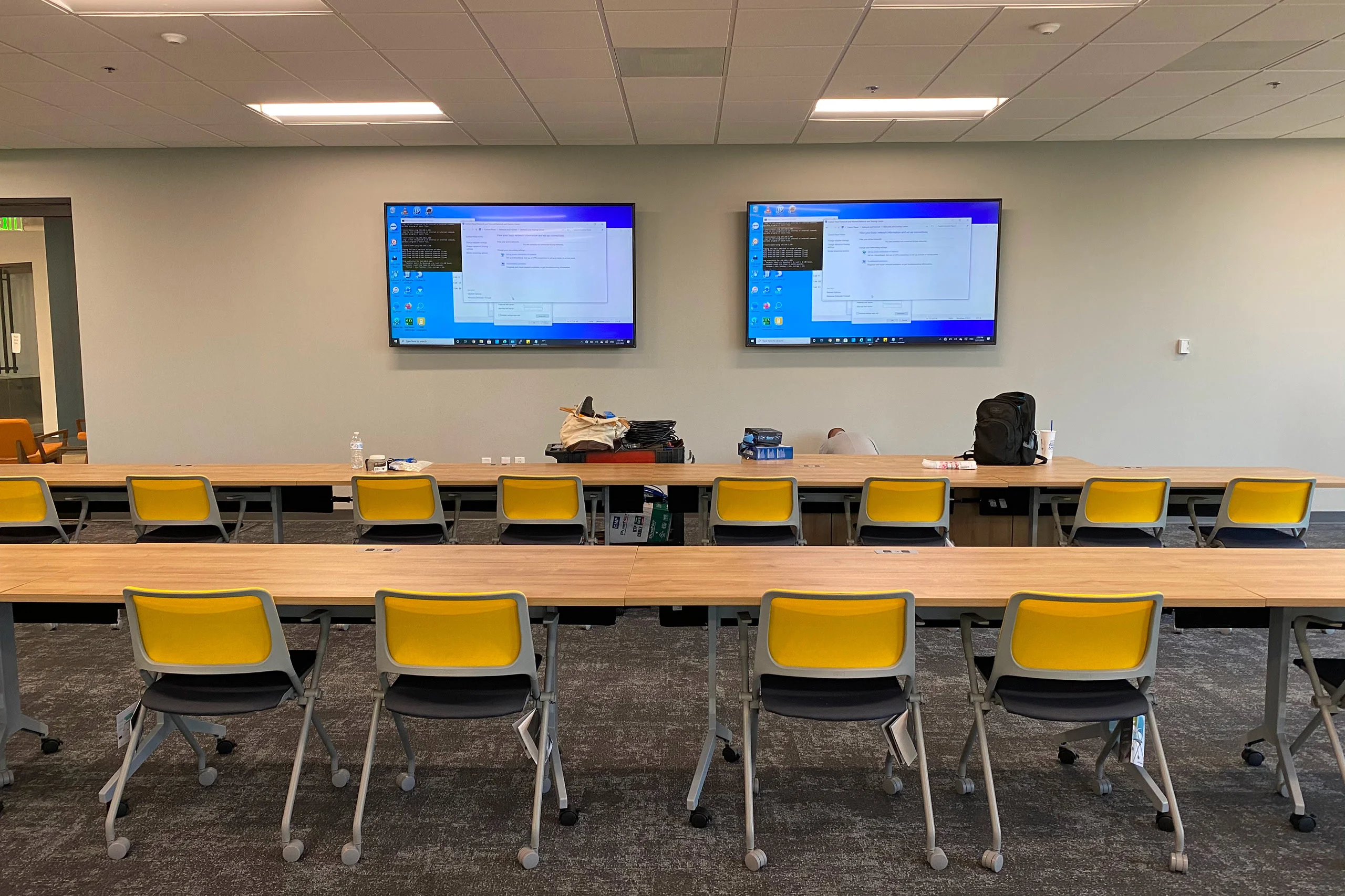 Empty classroom with yellow chairs and monitors