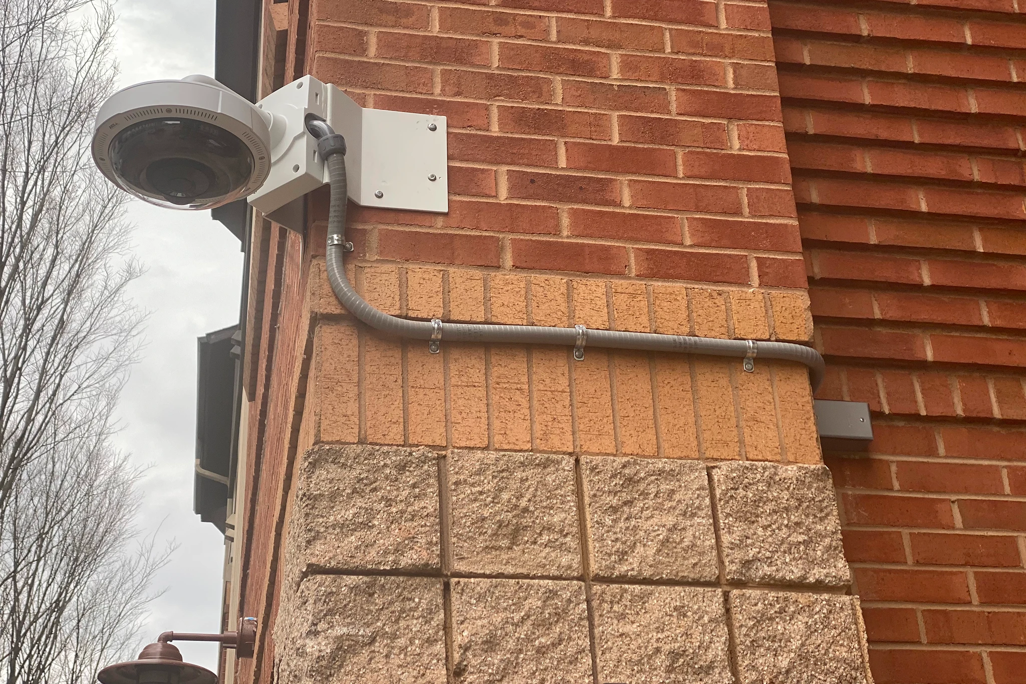 Dome security camera on brick building corner