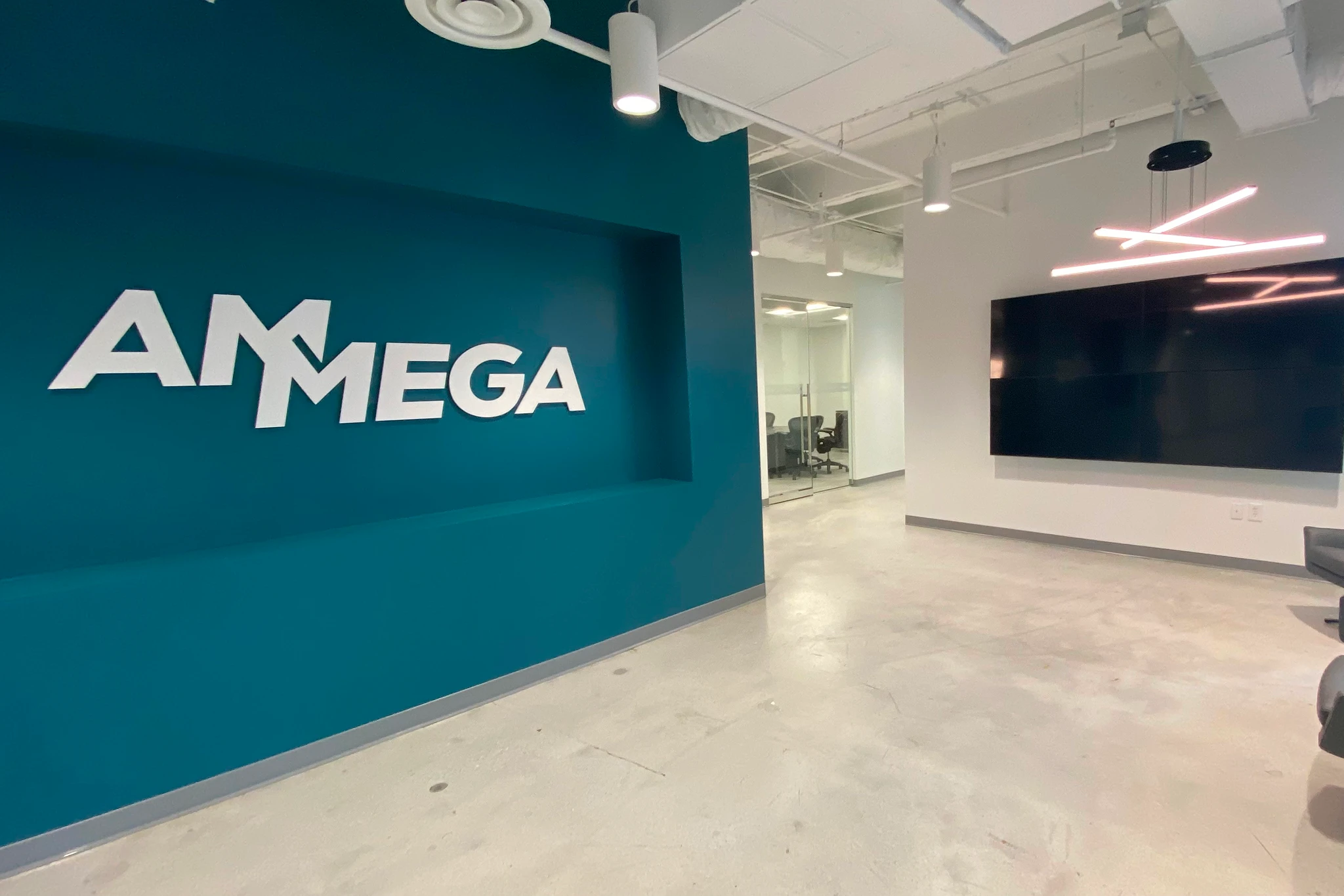 AMMEGA logo on teal office lobby wall